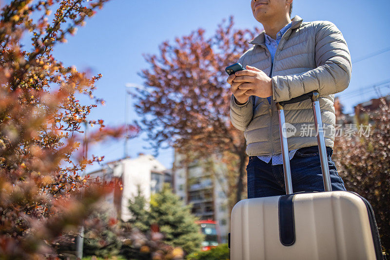 一个陌生的日本人带着行李旅行时使用手机