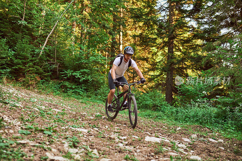 一个骑自行车的人在极端和危险的森林道路上骑自行车。有选择性的重点