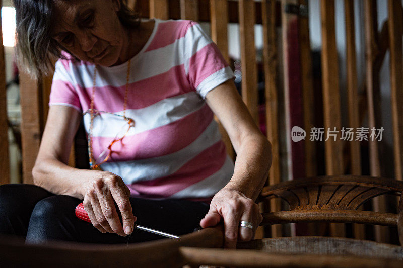 老婆婆退休了，在自己的车库式作坊里修木椅，这是她的爱好