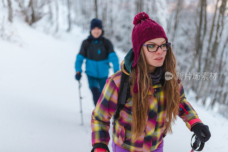 年轻女子和她的朋友在雪山上徒步旅行