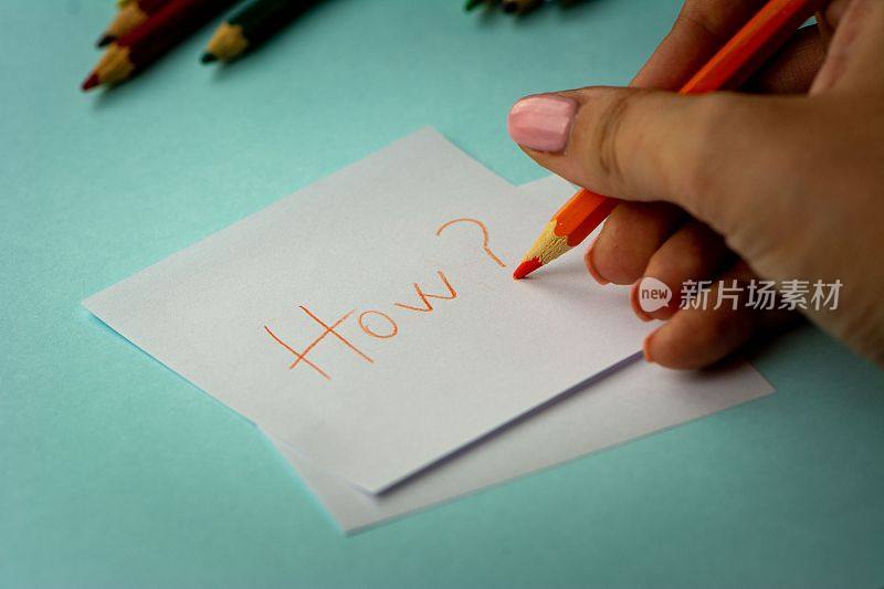 女人在一张纸上写字，背景是一些其他的铅笔
