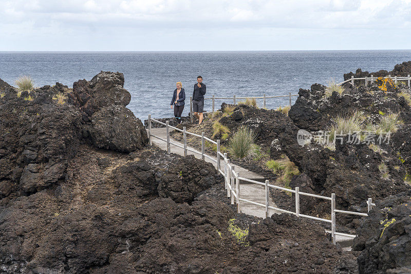 两个人在亚速尔火山海岸散步