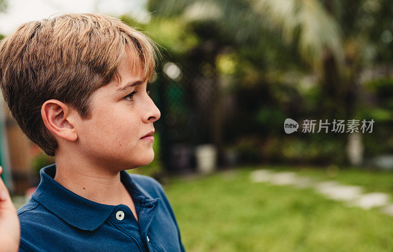 一个患有自闭症的青春期前男孩在户外的侧面肖像