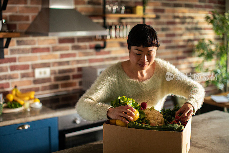 年轻的日本妇女在厨房里准备水果和蔬菜