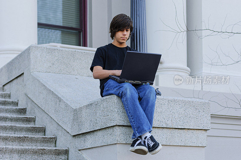 拉丁裔少年在学校台阶上学习