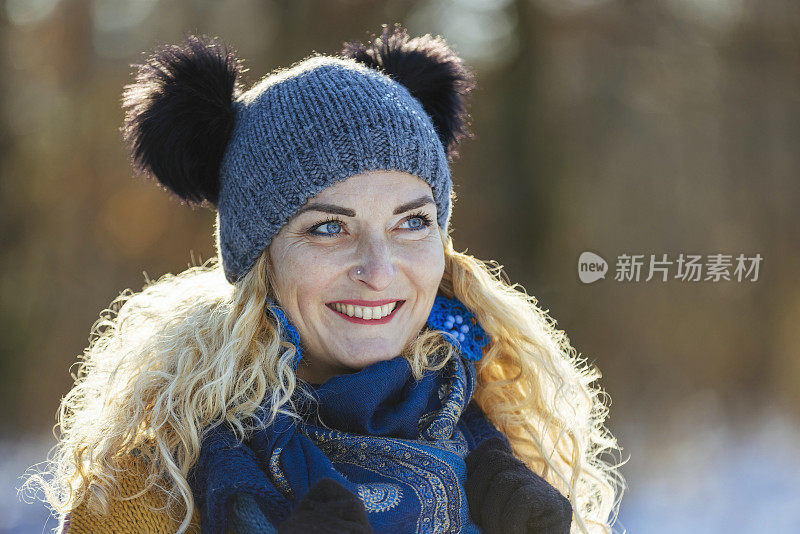 幸福的女人在冬天森林附近的白雪皑皑的草地