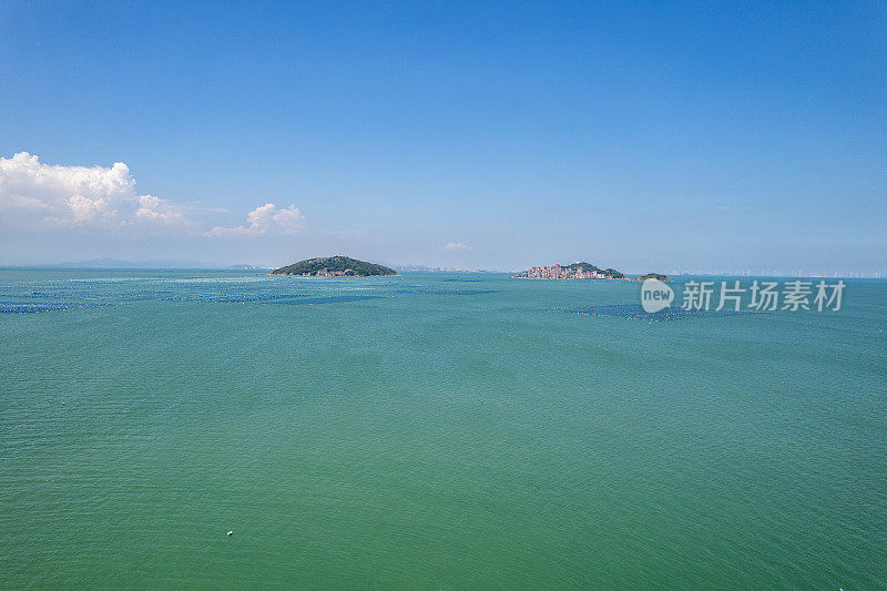 鸟瞰海中的小岛和海上漂浮的水产养殖场