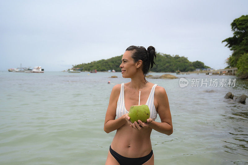 海边的女人，用椰子喝水