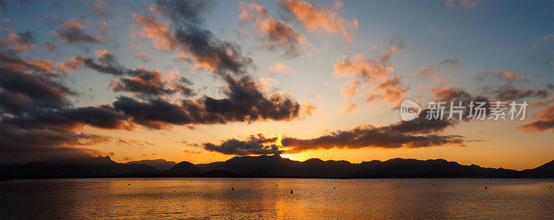 日落与戏剧性的天空在山脉和海洋在波伦卡湾