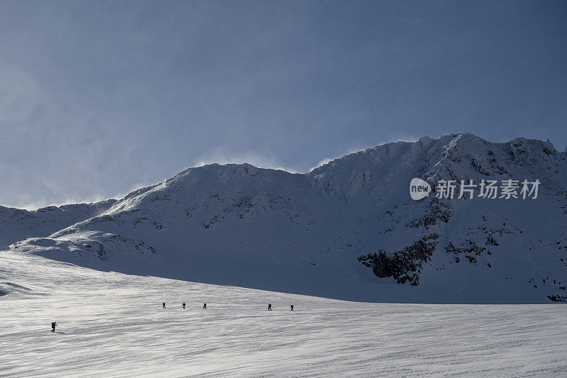 滑雪登山运动员攀登白雪皑皑的山峰