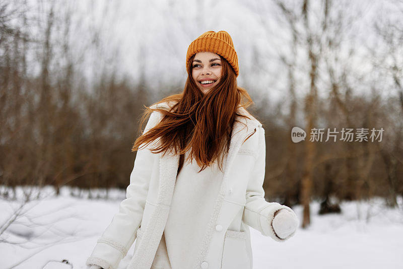 快乐的女人穿着冬衣戴着帽子有趣的冬天风景在冬天的森林里散步