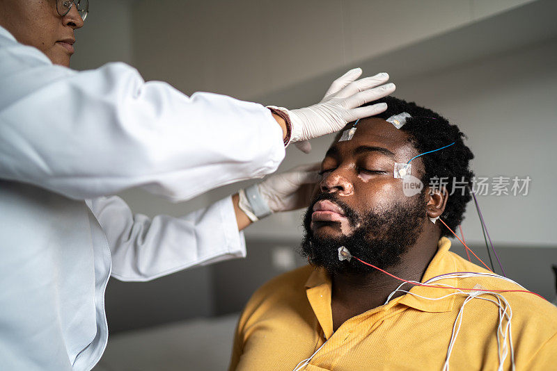 医生将电极放在病人头上进行多导睡眠检查(睡眠研究)