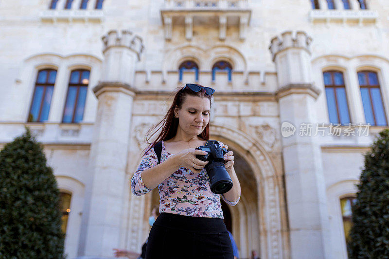 女游客看着她用相机拍摄的里雅斯特令人惊叹的建筑照片