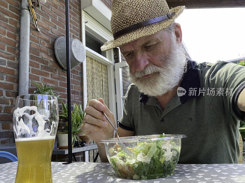 一位老人正在享用夏日午餐