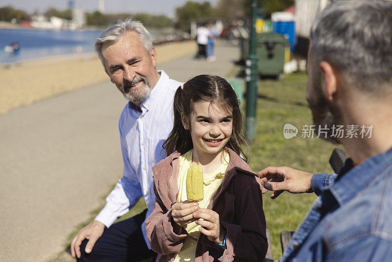 可爱的小女孩和爸爸、爷爷一起吃冰淇淋