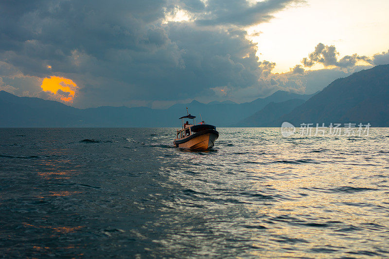 日落时分，危地马拉阿提特兰湖上小船的风景