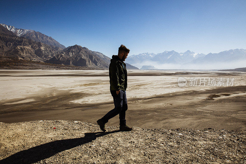 一名男子在巴基斯坦喀喇昆仑山脉的风景中