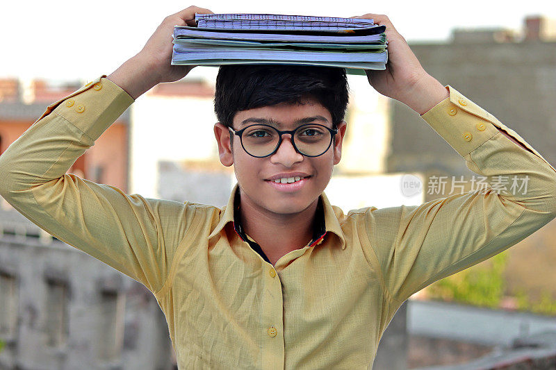 一名高中生在头顶平衡一堆书
