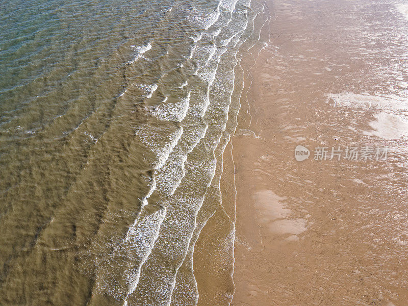 鸟瞰金色沙滩海岸线和浪花