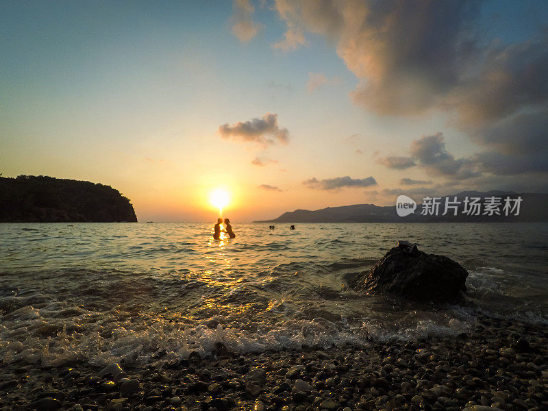 在美丽的夕阳下，海上有一对佳酿情侣