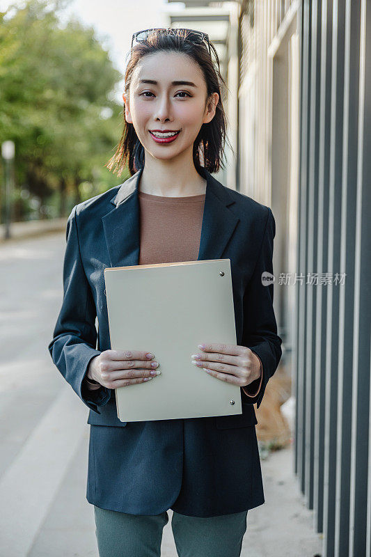 成功的女经理站在城市的大街上。