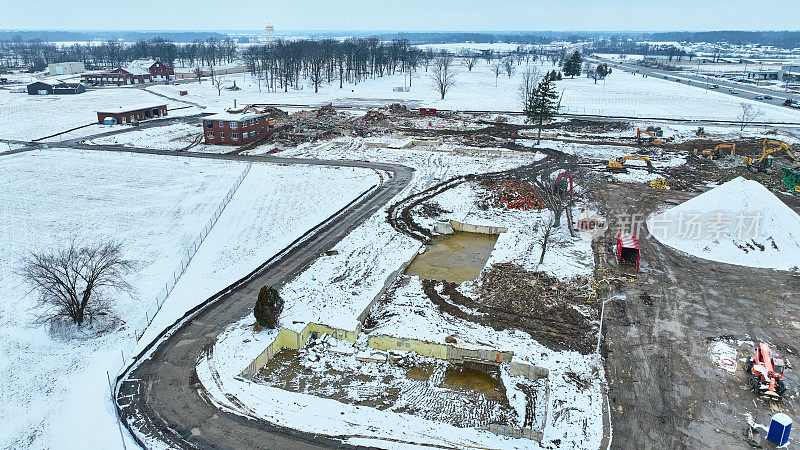 空中无人机拍摄的建筑工地积雪中露出的碎片