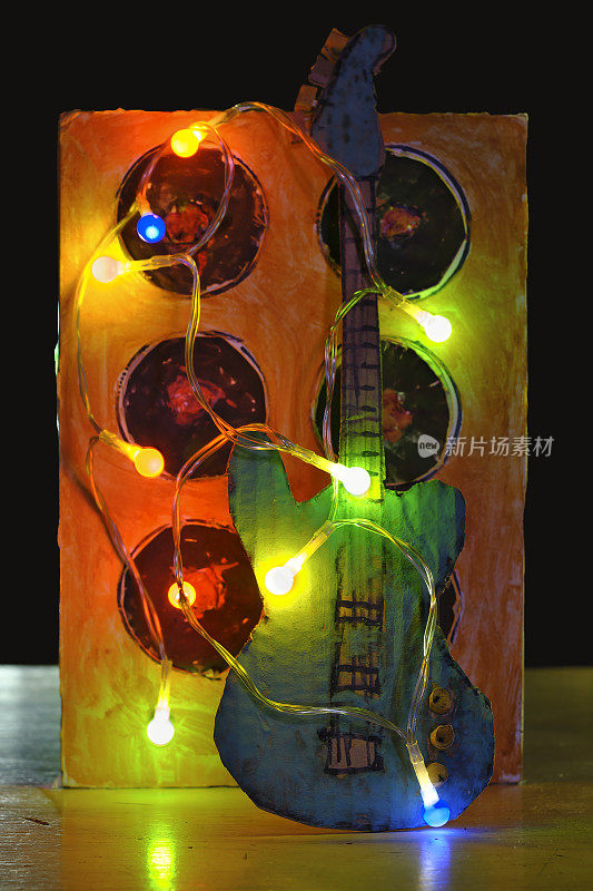 破旧的纸板吉他和放大器模型与灯，音乐，乐器，摇滚乐的概念
