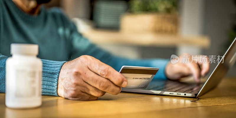 男性手持信用卡在网上买药