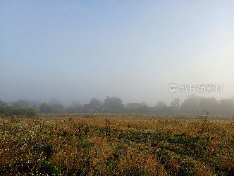 黎明时分，乌克兰一个风景如画的村庄笼罩在浓重的秋雾中。晨雾笼罩着村庄。
