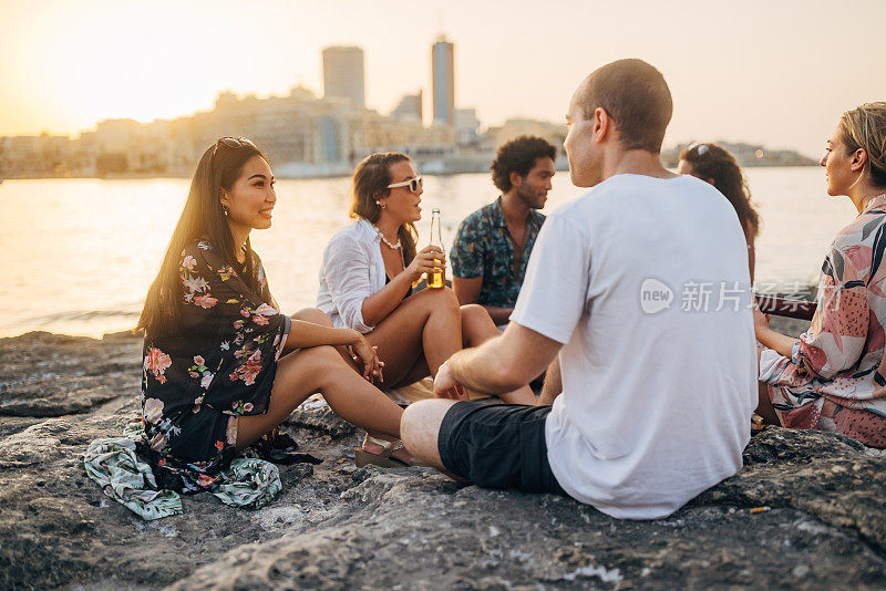 日落时分，一群朋友在沙滩上玩吉他