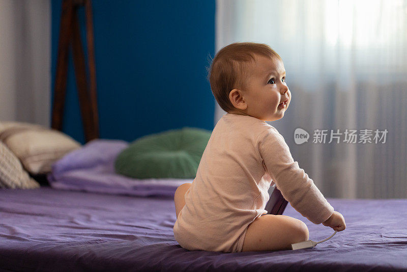 可爱的白人女婴坐在床上