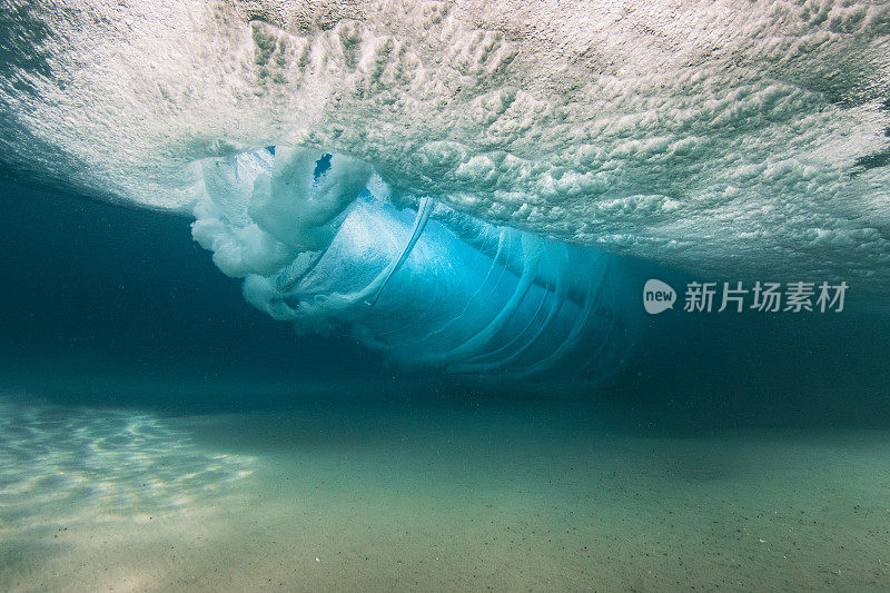 在清澈的海水中，海浪拍打着沙滩，水下的景色一览无余