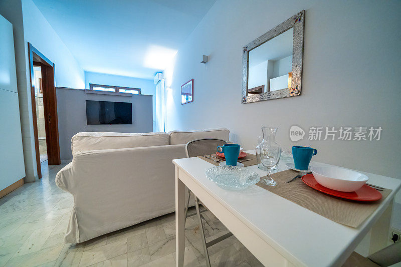 一房一床早餐公寓，白色室内设计，开放式空间:厨房带餐桌，客厅带沙发