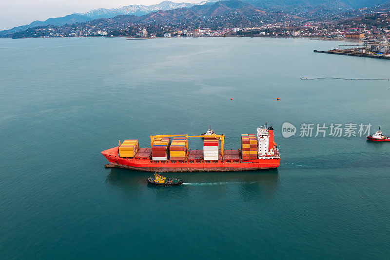 一艘满载进出口、商业物流和运输集装箱的货船驶出格鲁吉亚巴统海港的鸟瞰图。无人机的观点。货物运输