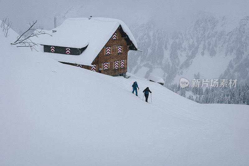 穷乡僻壤的滑雪者离开山上的小屋