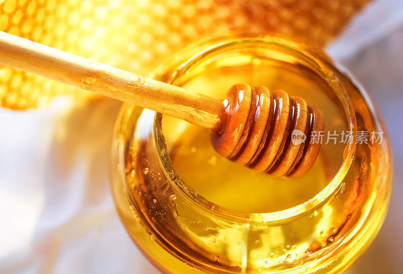 蜂蜜在一个玻璃罐子旁边的蜂巢