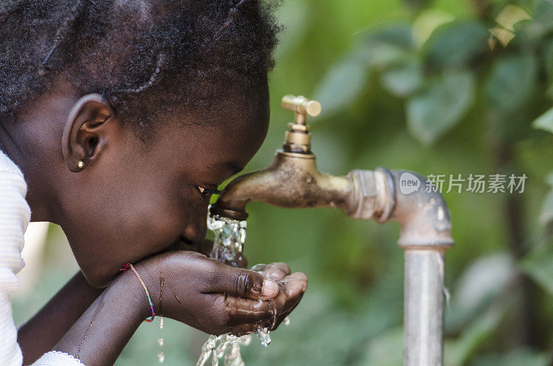 清洁淡水稀缺象征:黑人女孩从水龙头喝水