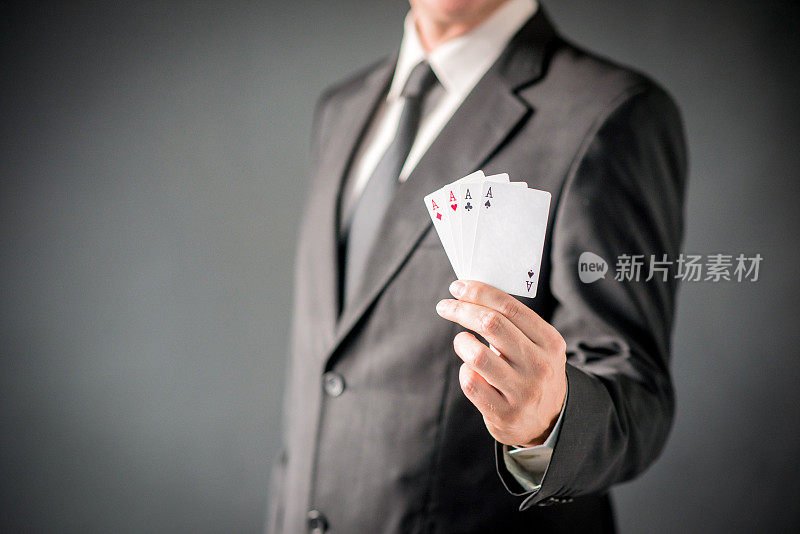 商人显示扑克的王牌在灰色的背景