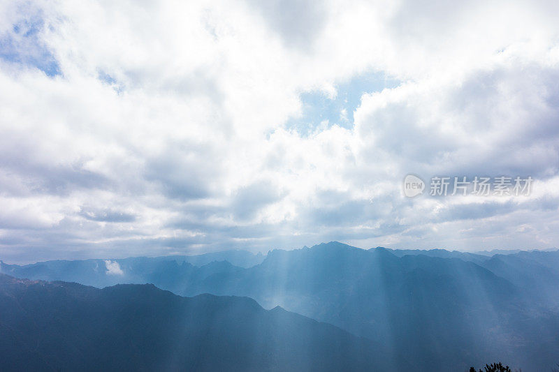 阳光透过云层在山上