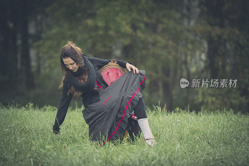 神秘主义的场景，红色的椅子和女人在大自然中