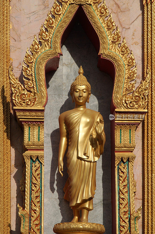 金佛雕像伫立在庙宇的墙壁上