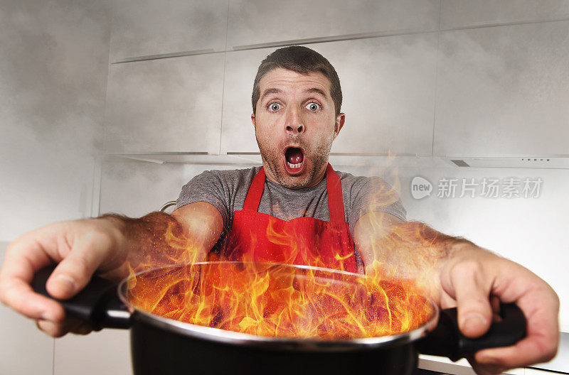没有经验的家庭厨师在恐慌的压力下拿着烧火的锅