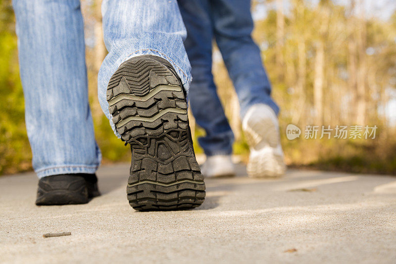 健康的生活方式。男人和女人走在人行道上。运动鞋。