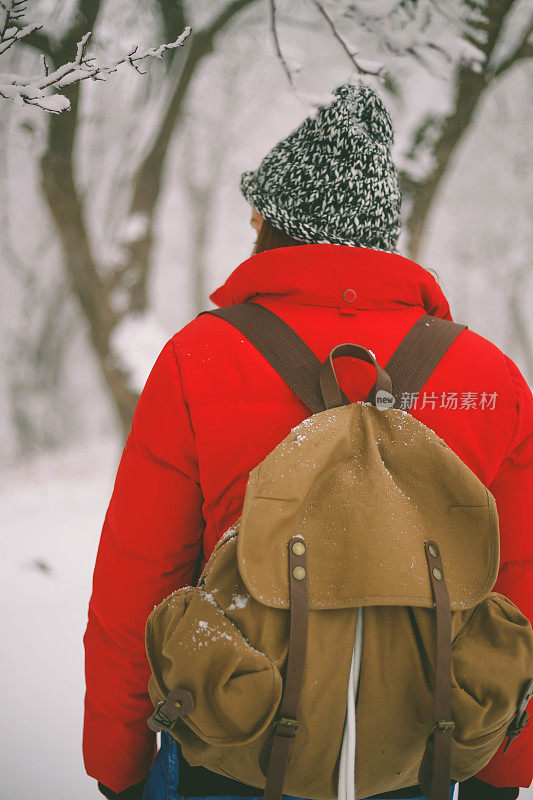 冬季运动活动。女徒步旅行者背包和雪鞋在雪地上的雪鞋