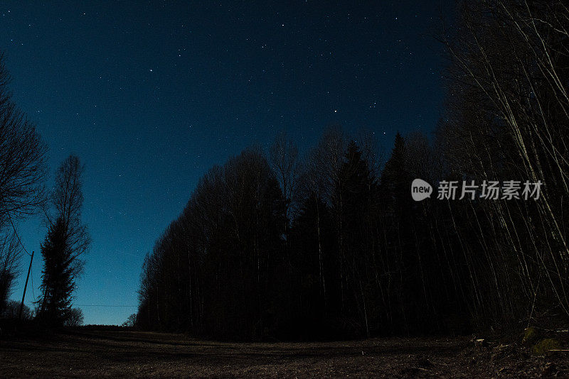 夜景照片的星星和一个房子亮在背景。