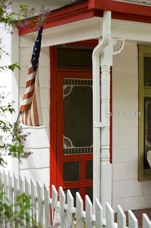 门廊上的白色尖桩栅栏旗和前门