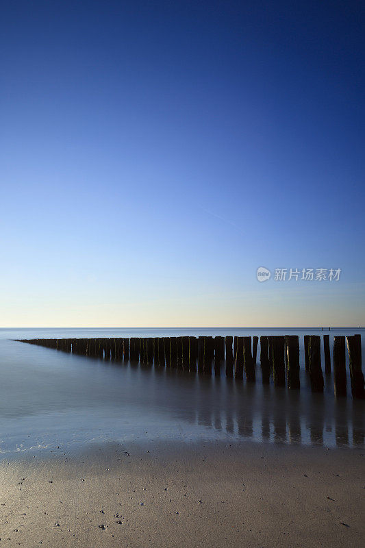 沿着荷兰海岸拍打着木制防波堤的海浪