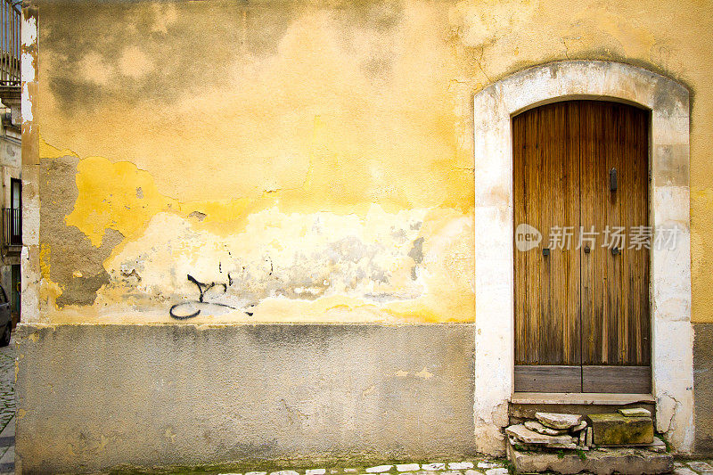 古老的西西里门口在美丽的斑驳黄墙
