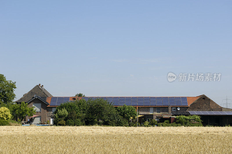 带有太阳能板和谷物田的农场建筑