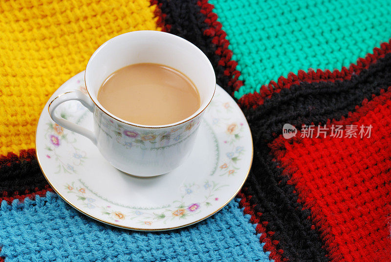 在阿富汗毛毯上用精致的瓷器餐具盛着一杯咖啡